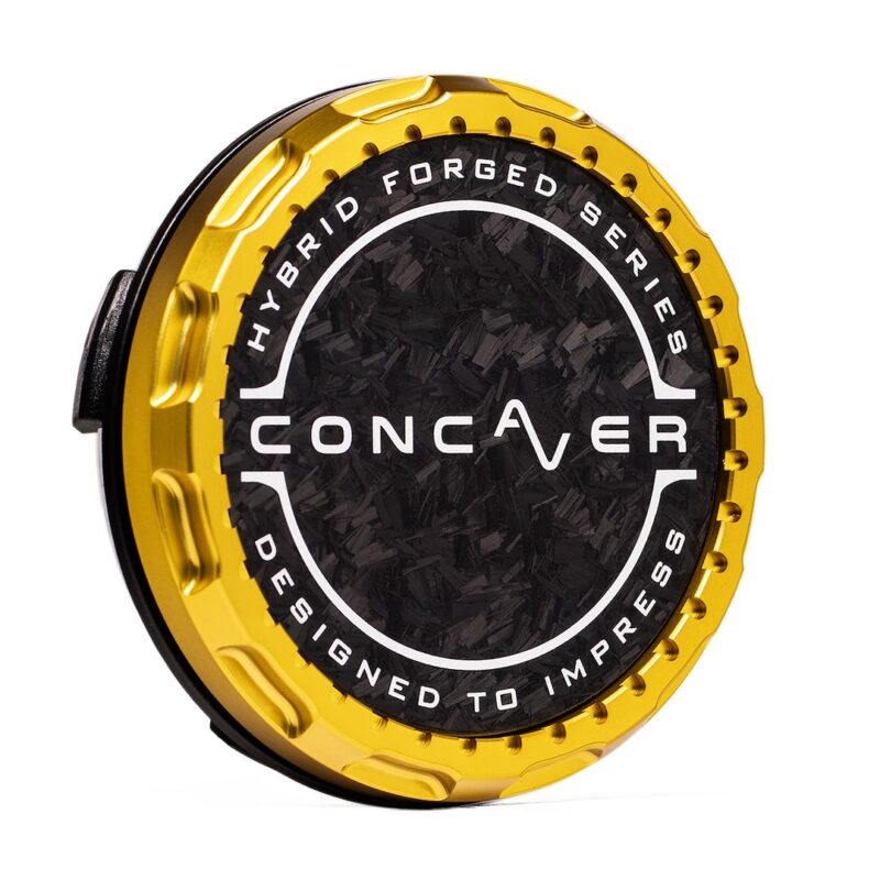 Gold circular car wheel center cap with black textured center, featuring the word CONCAVER and the edge text 'Designed to Impress'.