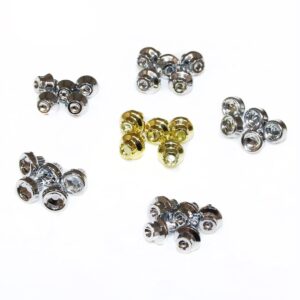 Set of small metallic acorn nuts in silver and gold hues arranged in clusters on a white background