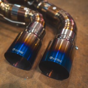 Close-up of two metallic exhaust tips with a blue-to-orange gradient and Valvetronic branding visible on the tips.