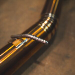 Close-up of a bicycle wheel with a striped yellow rim and a metal valve stem in the foreground.