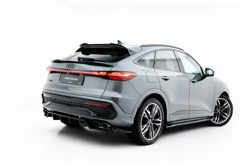 Rear three-quarter view of a silver Audi SUV with illuminated taillights and large alloy wheels, set against a white background.