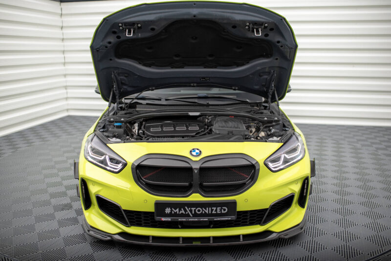 Front view of a neon yellow BMW with the hood open, exposing the engine bay and components; license plate reads #MAXTONIZED.