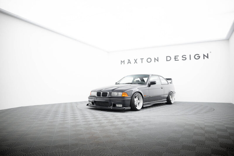 Silver BMW on a circular display in a bright white showroom with Maxton Design branding on the wall behind it.