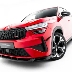 Front-left view of a red SUV showing a bold black grille, angular LED headlights, and large alloy wheels on a white background.