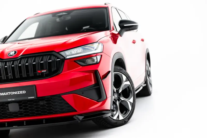Red Škoda SUV shown from the front-left, highlighting the bold grille, headlight, and large black alloy wheels.