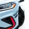 pol_po_Front-Bumper-Wings-Canards-Volkswagen-Jetta-GLI-Mk7-Facelift-2-23927_5webp - OPSHOLDERS Close-up of a light-blue car's headlight and front bumper, with a red accent stripe and black wheel visible.