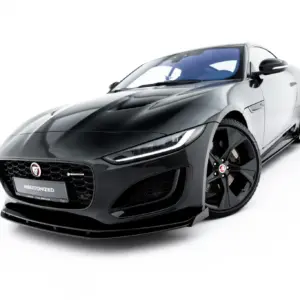 Front three-quarter view of a glossy black Jaguar sports car with a prominent grille and large alloy wheels against a white background, #MAXTONIZED on the plate edge.
