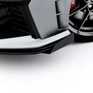 Close-up of a sleek car front bumper with a silver lip and a large alloy wheel edge visible on the right side.