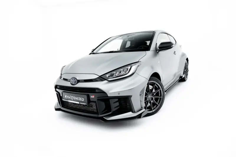pol_po_Front-Flaps-Flaps-Toyota-GR-Yaris-Mk4-Facelift-23785_5webp - OPSHOLDERS Silver Toyota sports car shown from a low front-right angle with a bold grille and large black alloy wheels on a white background.
