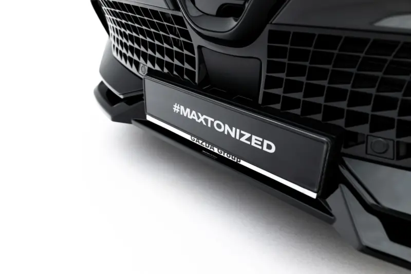 Close-up of a black car's front grille with a license plate reading #MAXTONIZED.