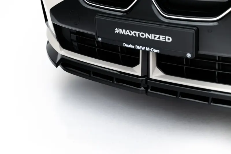 Close-up of a black BMW front bumper featuring a #MAXTONIZED plate and the 'Dealer BMW M-Cars' label.