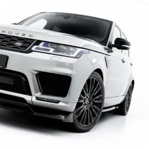 Front three-quarter view of a silver Range Rover SUV, highlighting the grille, headlight, and large black alloy wheel.