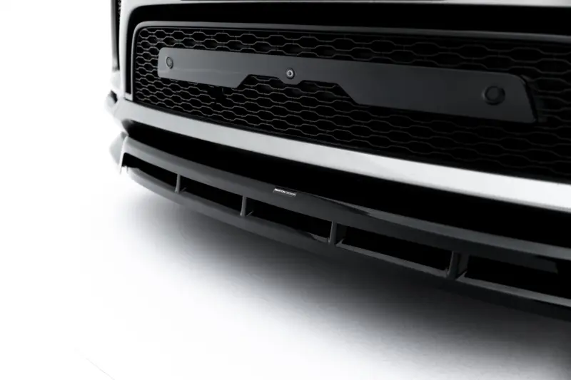 pol_po_Front-Splitter-Land-Rover-Range-Rover-Sport-Mk2-Facelift-23831_6webp - OPSHOLDERS Close-up of a black car front, highlighting the honeycomb grille and lower bumper with a Maxton Design badge visible on the lip.
