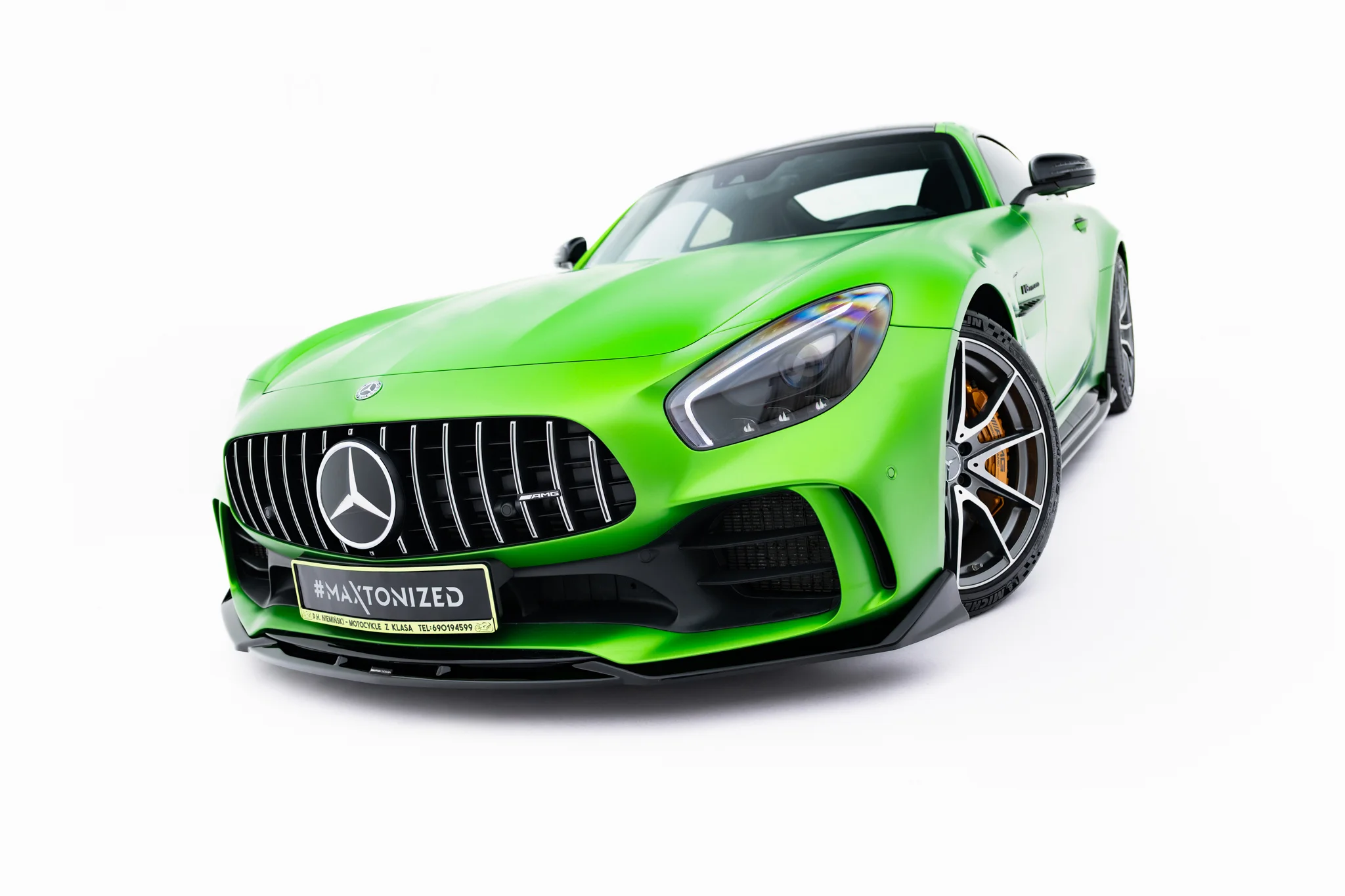 pol_po_Front-Splitter-Mercedes-AMG-GT-R-C190-Facelift-23888_6webp - OPSHOLDERS Bright green Mercedes AMG sports car shown from a low front-right angle, emphasizing the grille and headlight details.
