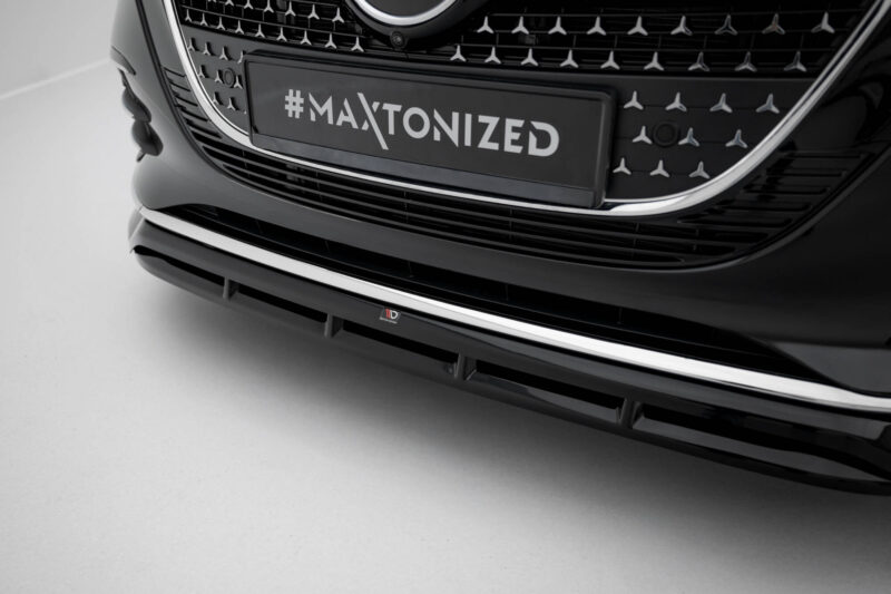 Close-up of a car's front grille and bumper with a license plate reading '#MAXTONIZED' in bold white letters on black.