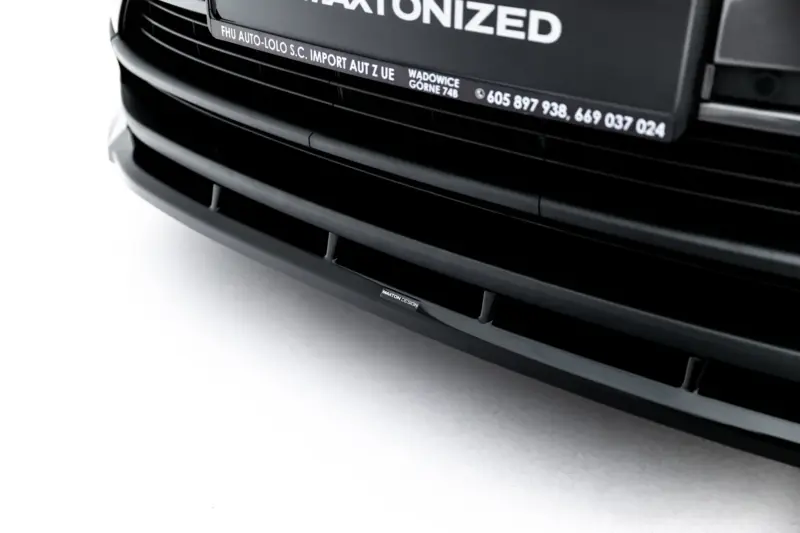 Close-up of a glossy black car front grille with curved horizontal slats and a small 'MAXTON DESIGN' badge