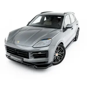 Front three-quarter view of a silver Porsche SUV with black grille and large alloy wheels against a white background in a studio-like shot.