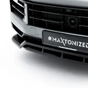 Close-up of a car front grille with a license plate reading '#MAXTONIZED' and 'Porsche Centrum Rzeszów' beneath it.