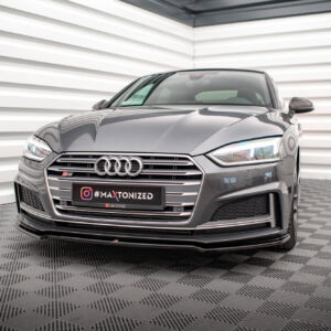 Front three-quarter view of a grey Audi sedan in a showroom, with a black plate reading #MAXTONIZED at the front.