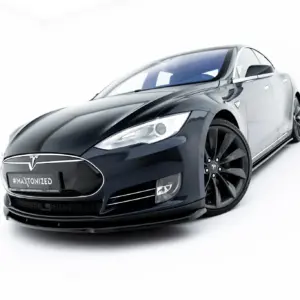 Front-left angled view of a sleek dark blue Tesla electric car on a white studio background, showing the distinctive front grille and emblem with #MAXTONIZED on the license plate