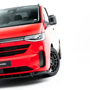 Front-left view of a red Volkswagen van showing the VW emblem, headlight, and bold grille with #MAXTONIZED on the bumper plate.