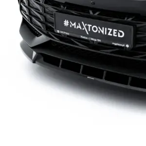 Close-up of a sleek black car front with a license plate reading #MAXTONIZED.