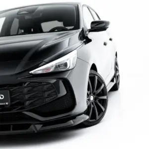Front-left view of a sleek black MG car, highlighting the emblem, grille, and sharp headlight against a white background with glossy finish.