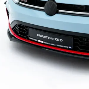 Close-up of a light-blue car front featuring the VW emblem, black grille, and a license plate with the hashtag #MAXTONIZED.