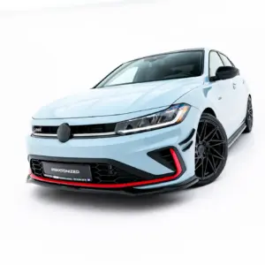 Front-left close-up of a light-blue sporty car in a white studio, highlighting bold front grille and large black wheels with red accents on the bumper badge reading '#MAXTONIZED'.