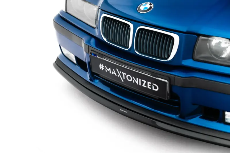 pol_po_Front-Splitter-V-3-BMW-M3-3-M-Pack-Coupe-Cabrio-E36-23875_1webp - OPSHOLDERS Close-up of a blue BMW front end, showing the kidney grilles and BMW emblem, with a license plate that reads '#MAXTONIZED'.