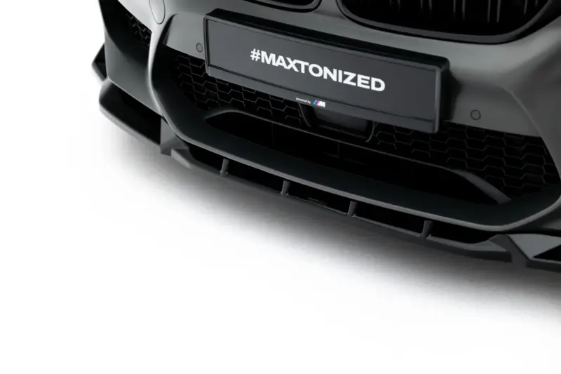 Close-up of a dark gray car bumper and grille with a plate reading #MAXTONIZED.