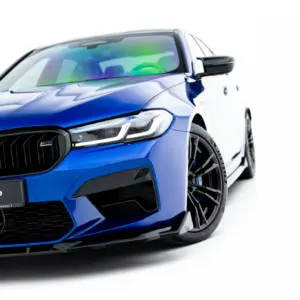 Blue BMW car close-up of front end, grille and headlight visible, with #MAXTONIZED on the bumper.