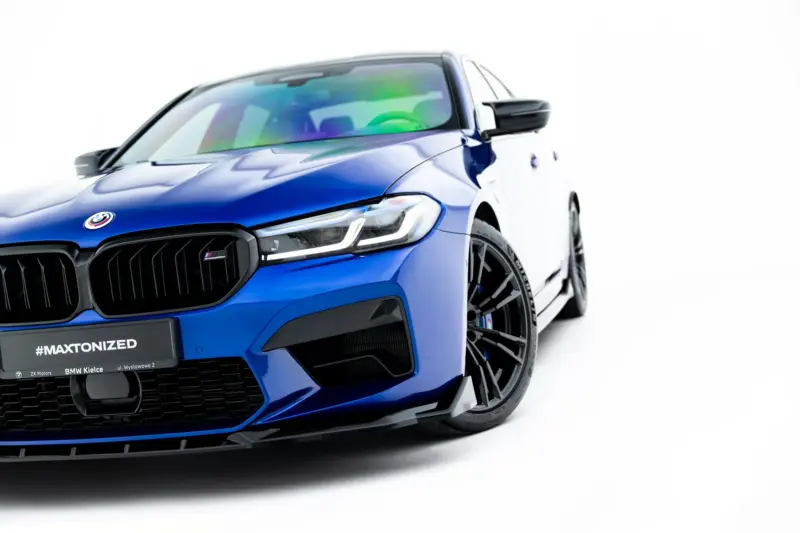 Blue BMW car close-up of front end, grille and headlight visible, with #MAXTONIZED on the bumper.
