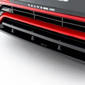 Close-up of a red Volvo front grille with black horizontal slats and the dealership text 'VOLVO NOVA ŁÓDŹ' above.