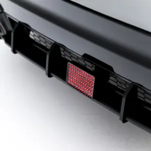 Close-up of a car's rear bumper showing a red LED taillight panel and hexagonal grille pattern