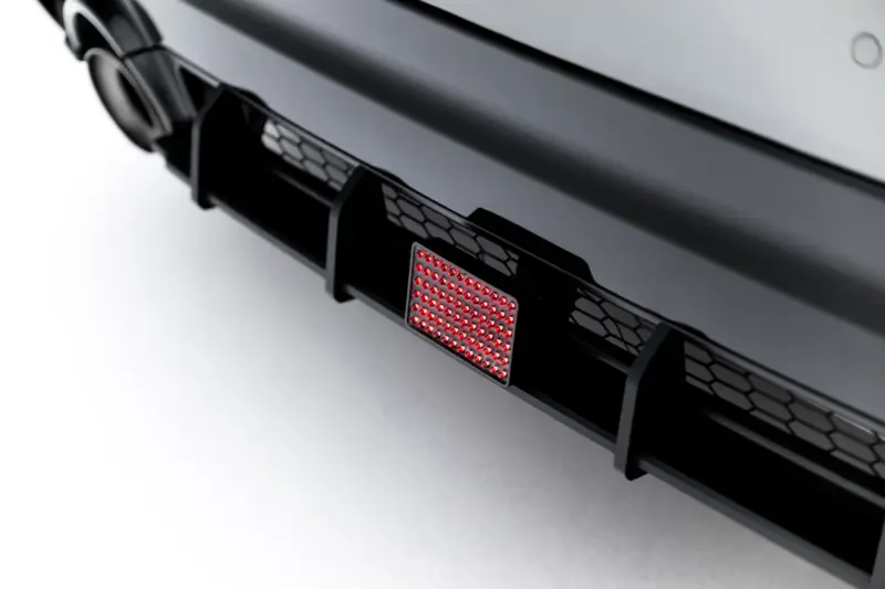 pol_po_Led-Stop-Light-Toyota-GR-Yaris-Mk4-Facelift-23789_1webp - OPSHOLDERS Close-up of a car's rear bumper showing a red LED taillight panel and hexagonal grille pattern
