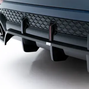 Close-up of a car front bumper with a honeycomb grille and a small Maxton Carbon badge