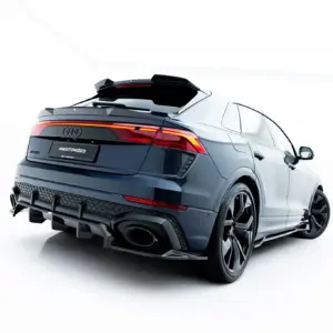 Rear three-quarter view of a dark blue Audi RS Q8 in a white studio backdrop, showing taillights and rear diffuser.