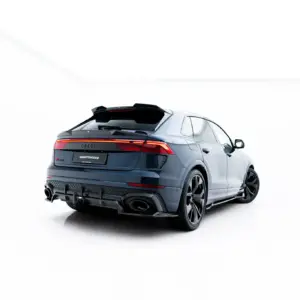 Rear three-quarter view of a blue Audi SUV in a white studio setting, with lit taillights visible on the back.