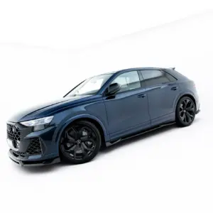 Blue luxury SUV photographed from a low front-left angle in a bright white studio backdrop, showing dark wheels and bold grille.