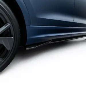 Close-up of a dark blue sports car’s side, showing the wheel, lower body panel, and carbon-fiber underbody edge.