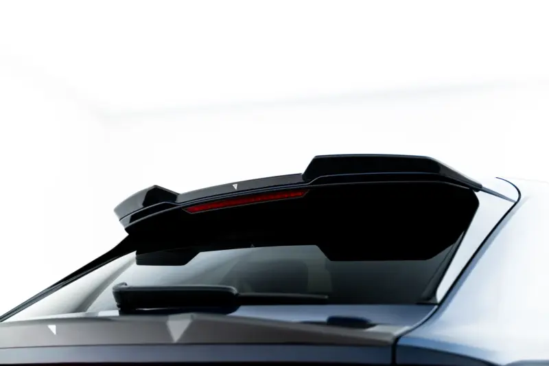 Close-up of a white car's rear with a black aerodynamic spoiler and a slim red taillight strip at the back.