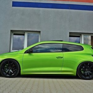 Lime-green sports hatchback parked on a paved driveway in front of a gray building with blue accents, black aftermarket wheels, lowered suspension.
