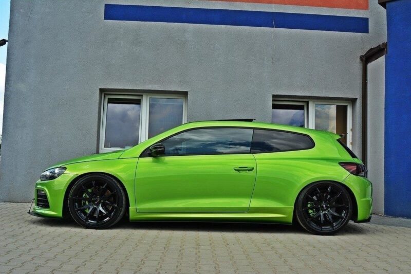 pol_po_RACING-SIDE-SKIRTS-DIFFUSERS-Volkswagen-Scirocco-R-Mk3-Mk3-Facelift-1768_2jpg - OPSHOLDERS Lime-green sports hatchback parked on a paved driveway in front of a gray building with blue accents, black aftermarket wheels, lowered suspension.