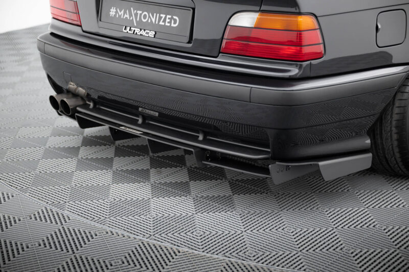 pol_po_REAR-DIFFUSER-BMW-M3-3-M-Pack-Coupe-Cabrio-E36-1829_1jpg - OPSHOLDERS Rear view of a dark car showing dual exhaust pipes and red/amber taillights on a textured floor, with a plate reading #MAXTONIZED.