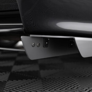 Close-up of a car's rear bumper and mounting plate area, showing the grey trim and small hardware underneath.