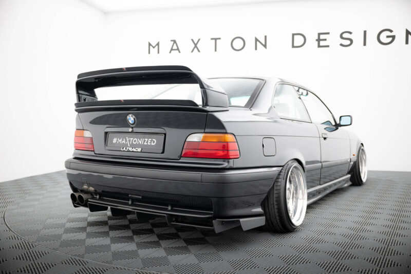 pol_po_REAR-DIFFUSER-BMW-M3-3-M-Pack-Coupe-Cabrio-E36-1829_3jpg - OPSHOLDERS Gray BMW with a large aftermarket rear wing on a showroom floor, displaying the #MAXTONIZED plate.