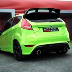 Lime‑green hatchback with a large rear spoiler and quad exhausts in a paved lot, Maxton Design badge on the rear.