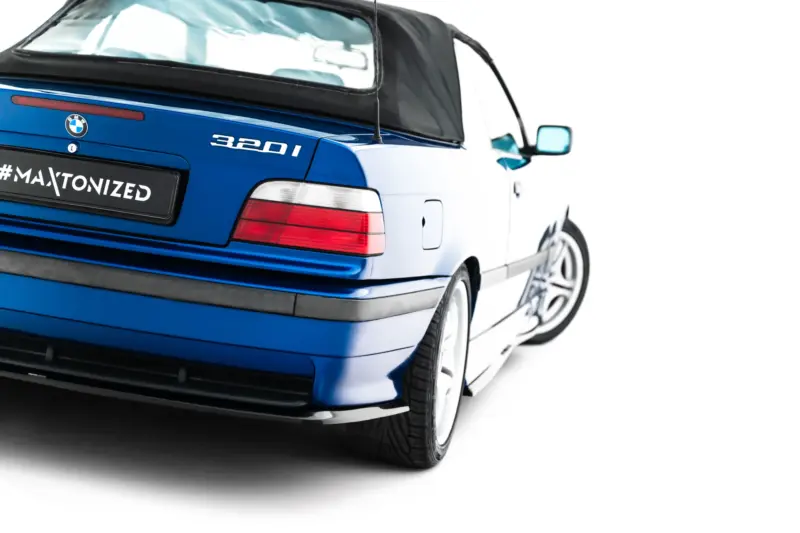 pol_po_Rear-Side-Splitters-BMW-M3-3-M-Pack-Coupe-Cabrio-E36-23876_2webp - OPSHOLDERS Blue BMW 320i rear-left view with a #MAXTONIZED license plate on a white background edge.