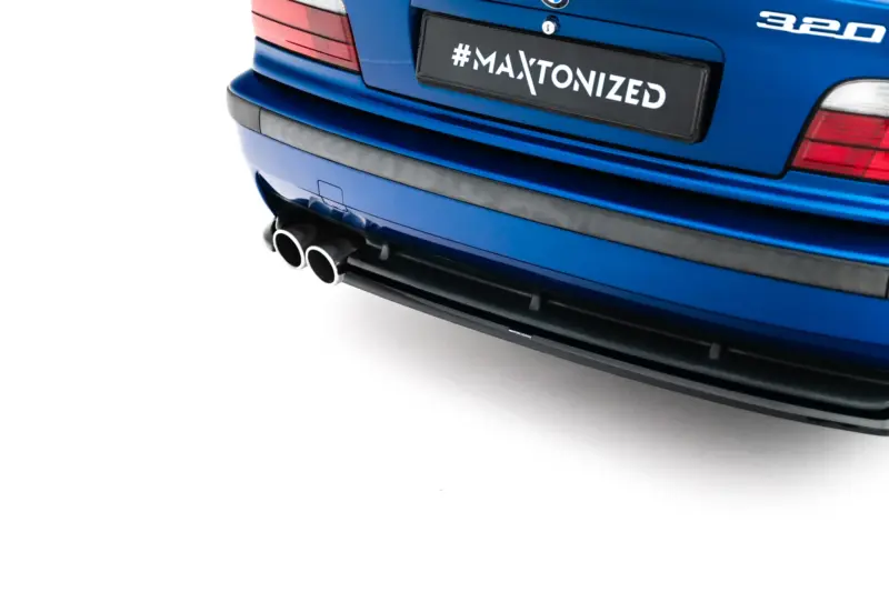 pol_po_Rear-Side-Splitters-BMW-M3-3-M-Pack-Coupe-Cabrio-E36-23876_3webp - OPSHOLDERS Rear of a blue car showing dual exhausts and a black plate reading #MAXTONIZED, with red taillights visible on the sides.
